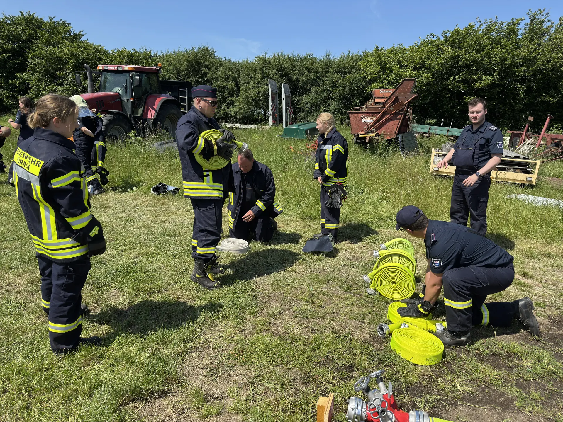 Feuerwehrleute rollen Schläuche zusammen
