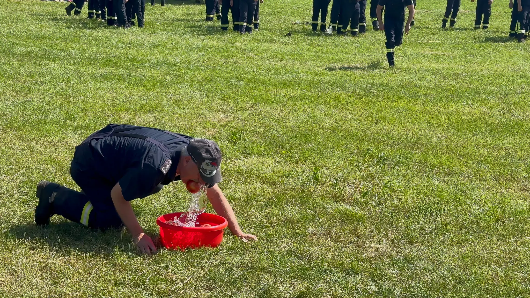 Spassspiel: Apfelbeissen, es muss ein Apfel aus einem Behälter mit Wasser gefischt werden. Dabei darf nur der Mund genutzt werden.