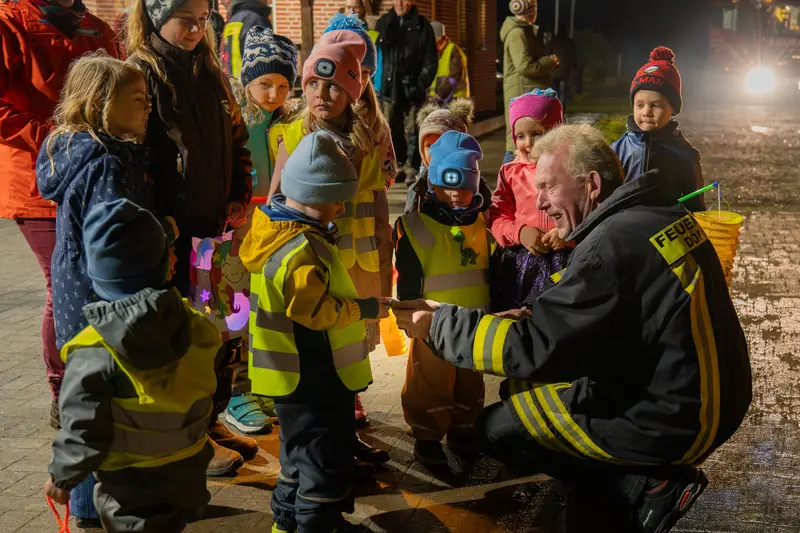 Bürgermeister Henning Jalas verteilt an die Kinder Karten für ein Getränk und eine Wurst